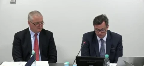 Mężczyzna w garniturze z okularami i mikrofonem na czole, otoczony logotypami AVIA i SD Eibar, noszący sprzęt audio.
