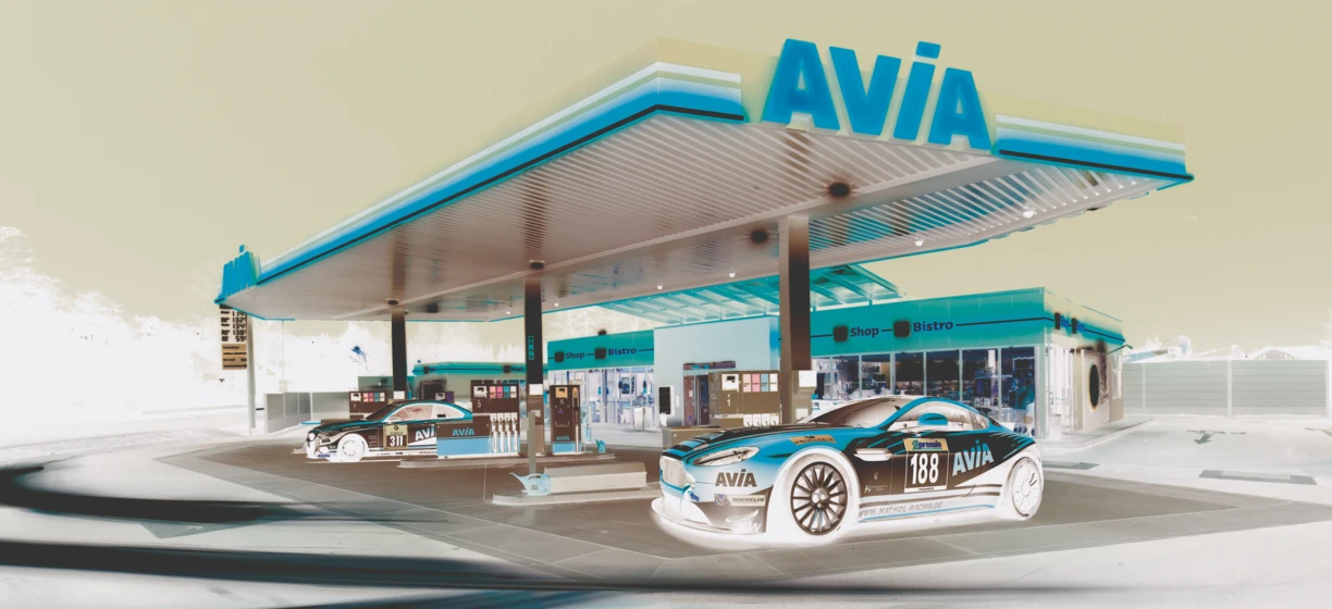 Stacja benzynowa z dystrybutorem paliwa AVIA i reklamą opon MICHELIN. Odwiedź sklep-bistro AVIA w celu skorzystania z ofert premio.