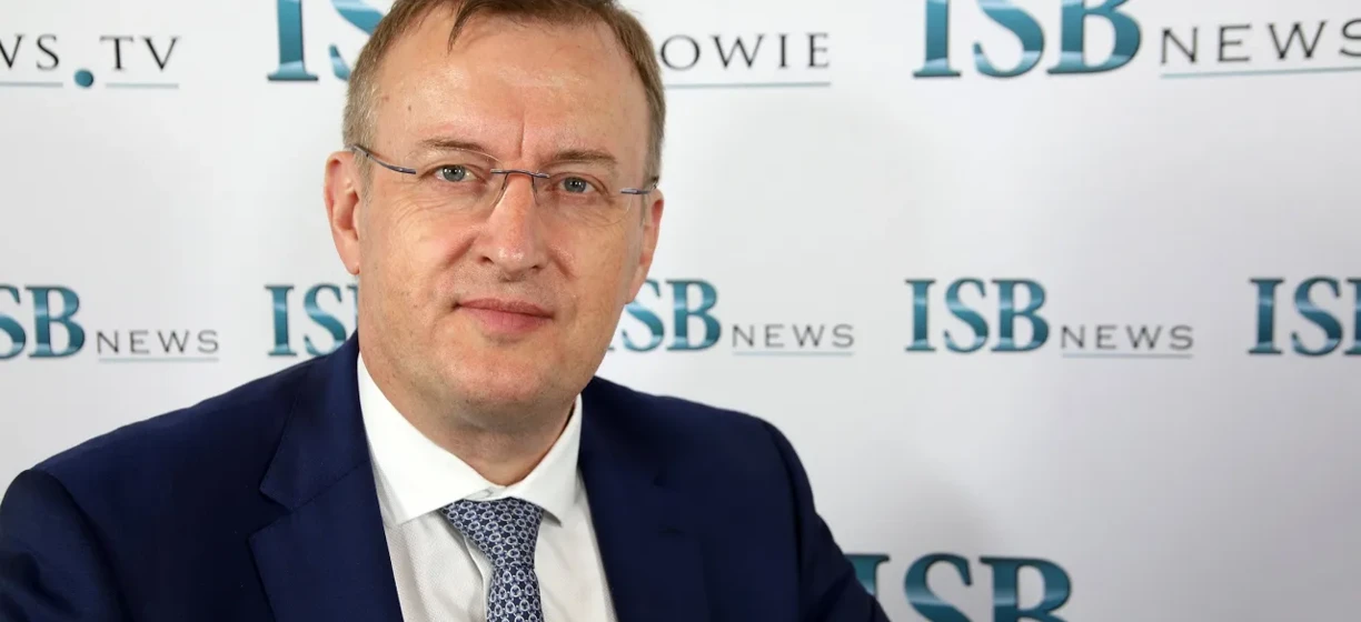 Profesjonalny pracownik umysłowy noszący okulary i eleganckie ubranie, oglądający telewizję w salonie optycznym.