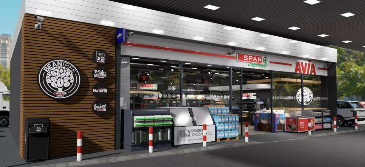 Shelving with various products and logos in a convenience store. SPAR logo prominently displayed. Fast food and retail options available.