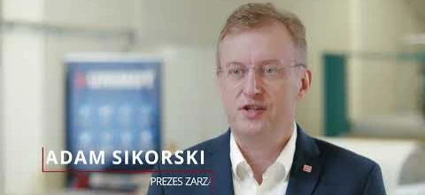 Mężczyzna noszący okulary i elegancką odzież, z białym kołnierzykiem i żakietem, reprezentujący Adama Sikorskiego, dyrektora generalnego. Dbając o wzrok i profesjonalizm.