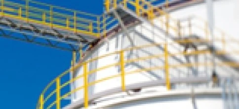 A metal storage tank in an industrial factory, made of composite material and steel cylinders. Expert engineering for efficient storage solutions.
