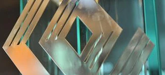 A modern graphic design of metal and glass with striking symmetry. Featuring a sleek aluminium finish and bold ונ typography.