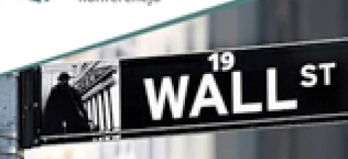 An aluminium street name sign on a wall, reading "WALL ST" and "Wall Street" in Polish language. The sign indicates the location of a conference at number 19 on Wall Street.