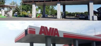 A sport utility vehicle parked at a filling station with various automotive lights and mirrors. AVIA branding visible.