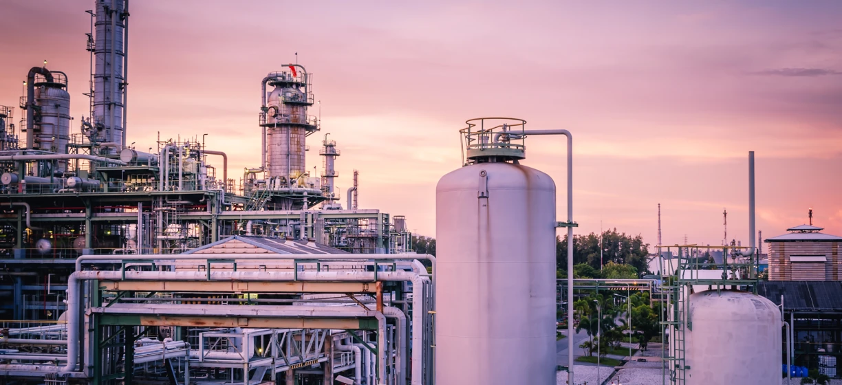Fabryka z przemysłowymi rurociągami, zbiornikami magazynowymi, stalowymi cylindrami i wysokim kominem dostarczającym energię elektryczną w elektrowni. Inżynieria w swojej najlepszej formie.