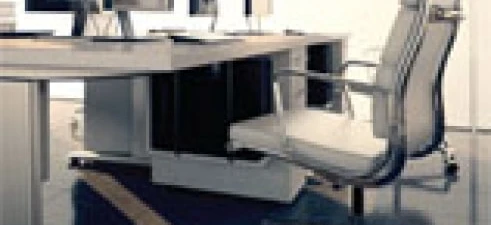 Modern office with sleek furniture including a comfortable chair, large computer desk, and computer monitor. Elegant interior design with a focus on functionality.
