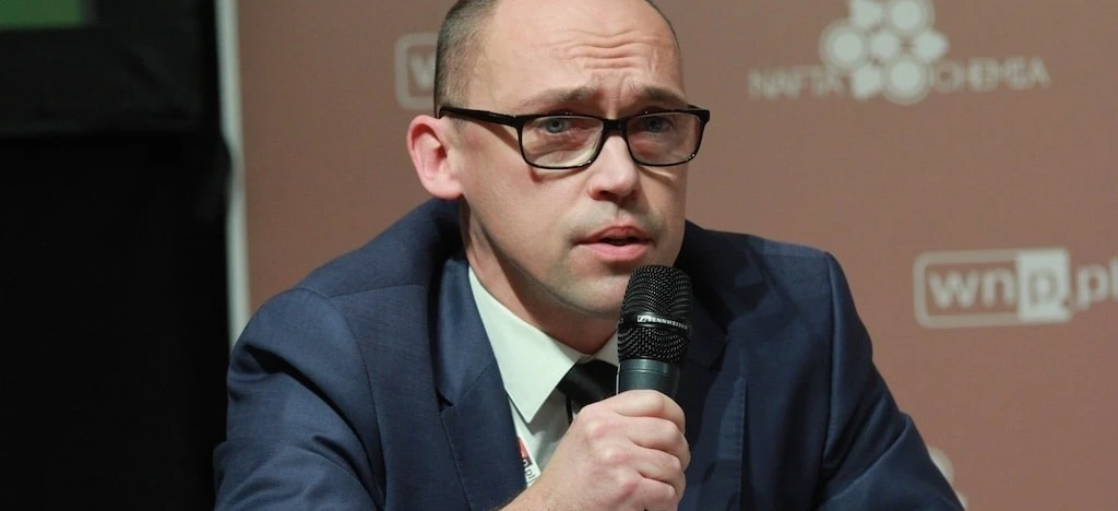 A person wearing glasses and headphones, with focus on their face and chin. COCHEMA logo featured prominently.
