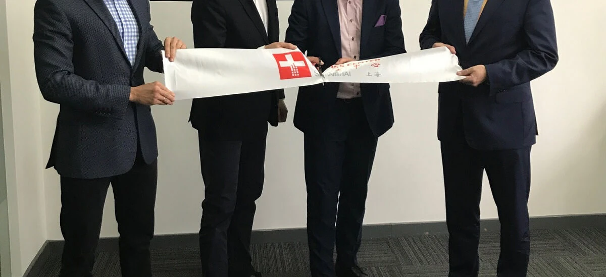 A man in a white-collar worker's suit stands confidently with a smile, wearing a blazer, trousers, and coat. He exudes professionalism and confidence in formal wear.