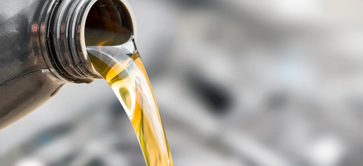 A clear bottle of motor oil, a fluid used for automotive care. This liquid is a solvent in chemical reactions.