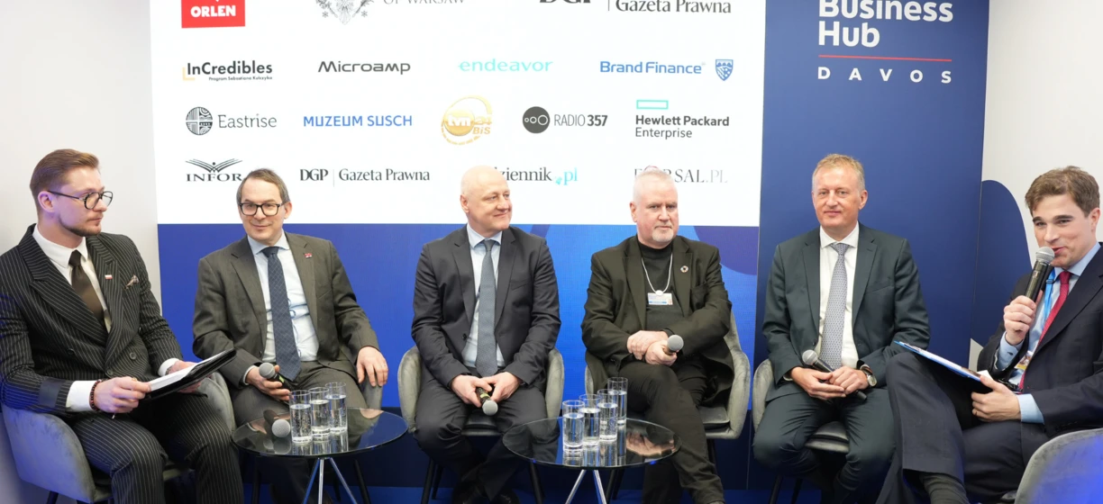 A group of well-dressed professionals in suits and blazers smiling and sharing knowledge at VOS 2025 event. Polish Business Hub represented by ORLEN, InCredibles, and more. #PolishBusiness #VOS2025 #KnowledgeSharing