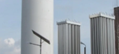 A storage tank made of composite material in an industrial factory setting with pipes and machines. Engineering marvels of cylinders and silos in action.