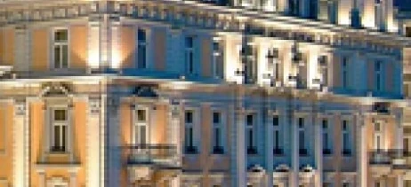 A luxurious hotel and palace glowing against the night sky in a bustling metropolis. Perfect for a lavish evening under the city lights.