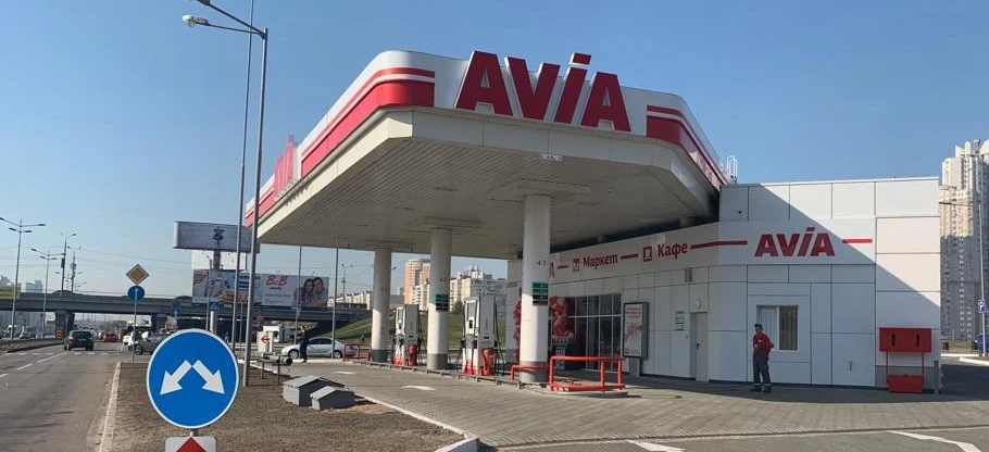 A sport utility vehicle parked at a filling station with a reflective rear-view mirror and tail & brake light. AVIA gas station in Poland.