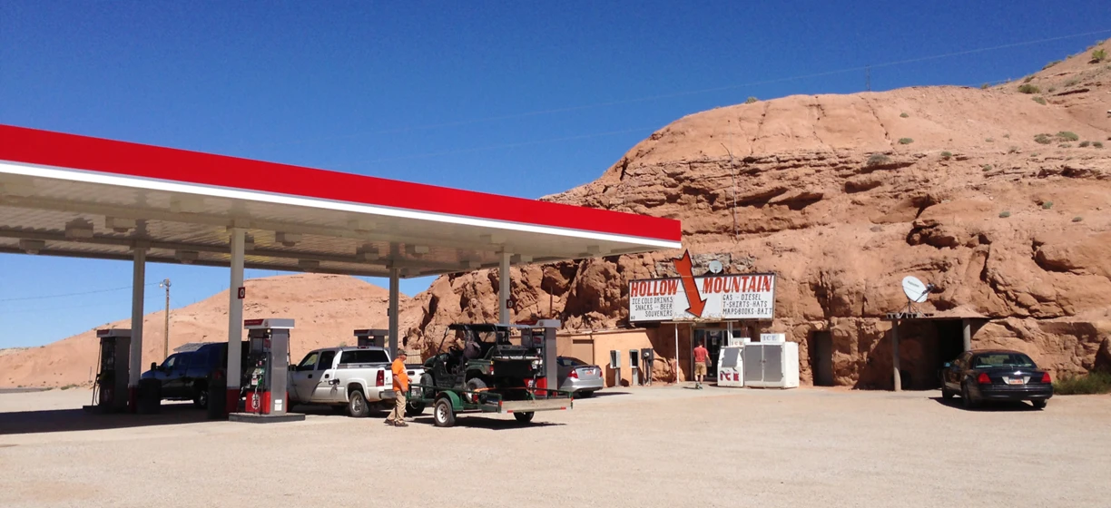 Title: Gas station at Hollow Mountain: supplies for road trip in aeolian landform. Truck fills up with gasoline next to geological formation.  Ice cold drinks, snacks, beer, souvenirs, and more available. #travel #outdoors #fuelstation #geology