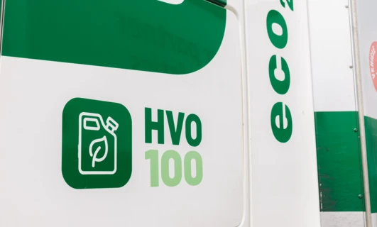Logo marki Q na samochodzie dostawczym promującym korzystanie z paliwa HVO 100 eco2 do ekologicznych operacji.