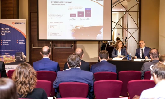 Polish Fuel and Energy Company UNIMOT showcasing their products at an event. Explore their selection of fuel, oils, and biofuels. Branding and interactive displays invite interaction with attendees.