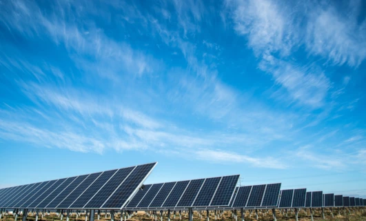 Błękitna tablica słoneczna pod dziennym słońcem, wydobywająca energię słoneczną w efektywny sposób. Innowacyjna technologia przechwytująca światło słoneczne pomimo kilku chmur na niebie.