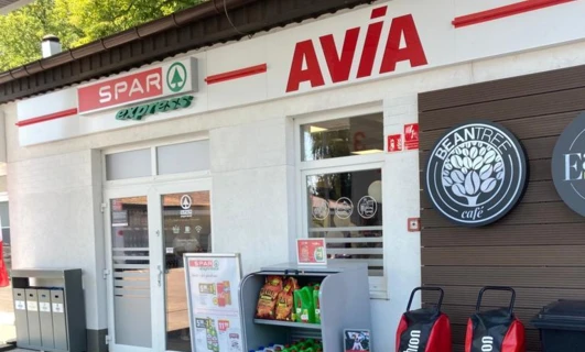 Obraz pojazdu typu sport utility z logo SPAR na środku felgi, pokazujący system kół samochodowych oraz bieżnik. Tylnie i stopowe światło, drzwi samochodu oraz scena parkowania w tle. Słowa kluczowe: SPAR, ekspres, ochrona przed ogniem, AVÍA, pielęgnacja opon.