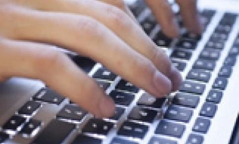 A person's finger typing on a computer keyboard, an essential input device for office equipment. Enhance your productivity with this electronic peripheral.