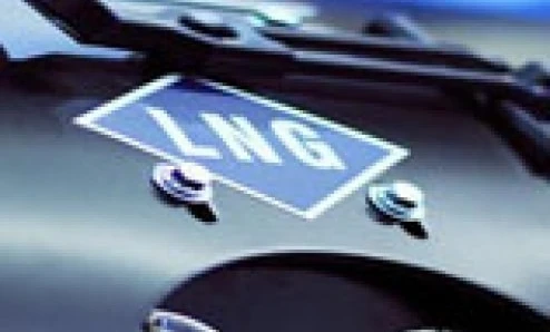 A classic car with a logo on the hood being measured using a measuring instrument. It is a sports car kit in progress.