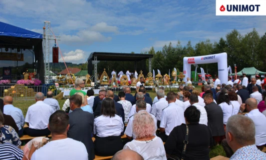 Wydarzenie publiczne z tłumem zgromadzonym przy scenie na wydarzenie społecznościowe z prelegentami i sponsorami. Polski tekst obejmuje datę "8.08.2024", "Laura B" oraz różne nazwy firm.