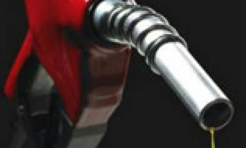 A still life photograph showing a red fuel dispenser with a nozzle and tap. Household hardware with gasoline for SEO best practices.