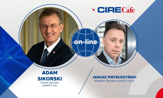 Biznesmen w garniturze i krawacie pracujący online. Słowa kluczowe: Garnitur, ubiór formalny, technologia, praca online, osoba biznesowa.