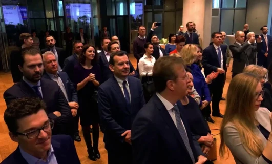 Grupa ludzi w strojach formalnych stojących razem, w tym pracownicy umysłowi w garniturach i marynarkach. Uczestnicy konferencji CHA nawiązujący kontakty.