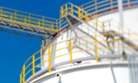 A metal storage tank in an industrial factory, made of composite material and steel cylinders. Expert engineering for efficient storage solutions.