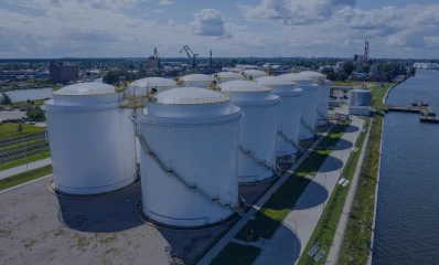 Wysoka zbiornik na składowanie zboża odbijający się w wodzie na zewnątrz fabryki w otoczeniu przemysłowym. Jasny i pogodny dzień. Atmosfera przemysłowa.