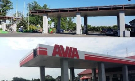 A sport utility vehicle parked at a filling station with various automotive lights and mirrors. AVIA branding visible.