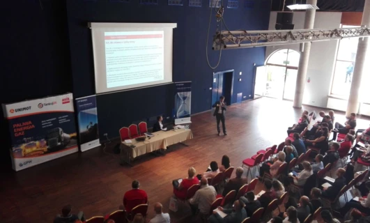 Auditorium display of technology and furniture at UNIMOT event in a conference hall. Keywords: Furniture, Event, Chair, Electronic device, Auditorium, UNIMOT.