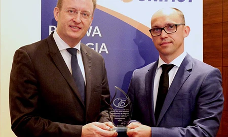 Uśmiechnięty pracownik biurowy w eleganckim garniturze i marynarce, kompletny z koszulą i krawatem. Słowa kluczowe: Kołnierz, Odzież wierzchnia, Płaszcz.