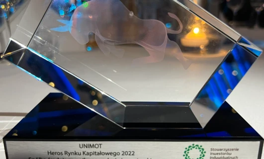 Srebrny puchar w szklanej gablocie z logo UNIMOT za najlepsze relacje inwestorskie w nagrodach Market Heroes 2022.