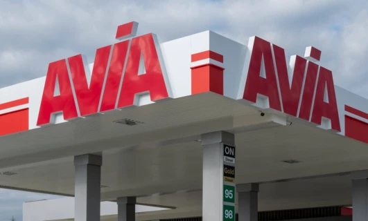 Image of various vehicles parked at a filling station with fuel options like Diesel 95, Diesel 98, Diesel 96 from AVIA and AVA.