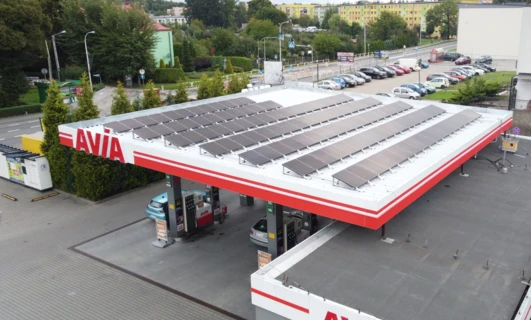 Samochód zaparkowany na stacji benzynowej AVIA z pełnym bakiem paliwa. Tablica rejestracyjna pojazdu widoczna na zdjęciu.