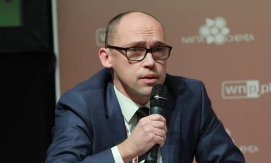 A person wearing glasses and headphones, with focus on their face and chin. COCHEMA logo featured prominently.