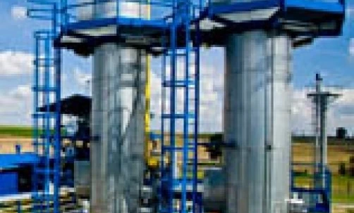 A metal cylinder seen inside a factory, showcasing engineering and industrial manufacturing. Made of composite materials stored in a metal tank.