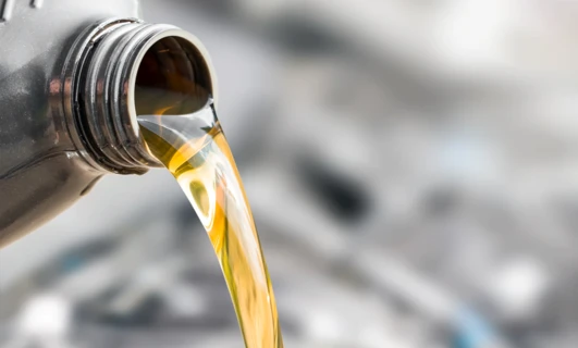 A clear bottle of motor oil, a fluid used for automotive care. This liquid is a solvent in chemical reactions.