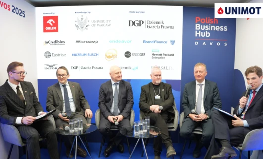 Grupa dobrze ubranych profesjonalistów w garniturach i marynarkach uśmiechających się i dzielących się wiedzą podczas wydarzenia VOS 2025. Polski Polish Business Hub reprezentowany przez ORLEN, InCredibles i innych. #PolskieBiznes #VOS2025 #DzielenieSięWiedzą