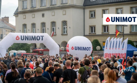 Zatłoczone publiczne wydarzenie z transparentami i logo reklamowymi. Ekscytacja unosi się w powietrzu podczas wydarzenia na Uniwersytecie Nove de Julho.