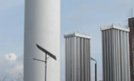 A storage tank made of composite material in an industrial factory setting with pipes and machines. Engineering marvels of cylinders and silos in action.