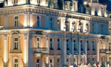 A luxurious hotel and palace glowing against the night sky in a bustling metropolis. Perfect for a lavish evening under the city lights.