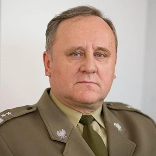 Oficer wojskowy w galowym mundurze, w komplecie z białym kołnierzykiem i zmarszczkami na czole, dumnie stoi. To zdjęcie oddaje profesjonalizm i władzę osoby wojskowej.