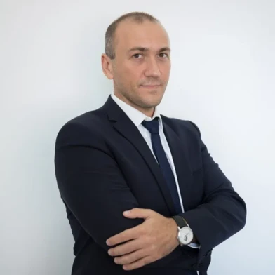 Зближене фото білокравтого робітника у офіційному одязі, яке показує їх брову, чоло, плече, комірець і щоку. На них надіто сорочку та піджак.