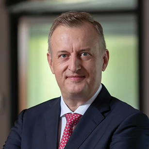 Zblizenie twarzy mezczyzny ukazujacej jego brode, brwi, czolo i kolnierzyk w formalnym ubraniu. Jego skora jest czysta, a linia jego szczeki jest wyraznie zarysowana.