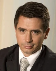 A close-up of a white-collar worker in a suit, with a raised eyebrow and a serious expression on their face.