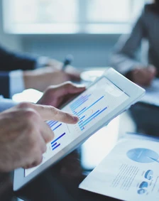 Profesjonalny pracownik umysłowy podczas spotkania korzystający z technologii do nauki, zarządzania pracą oraz współpracy za pomocą gestów i urządzeń komunikacyjnych.