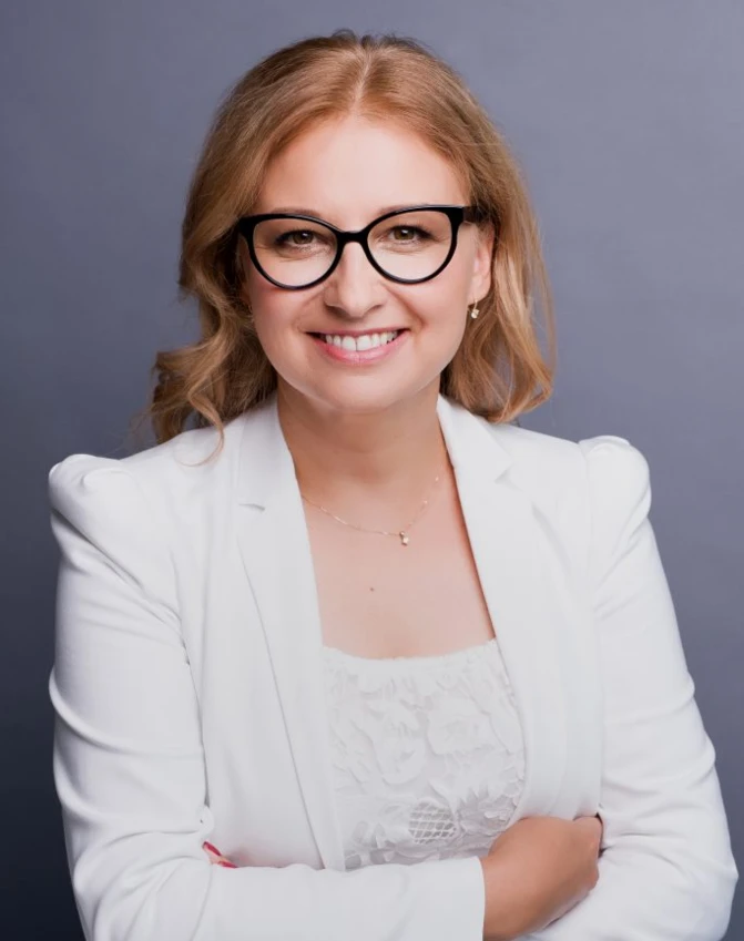 A person with a bright smile wearing stylish eyewear. They have well-groomed hair and a happy expression. Impeccable vision care.